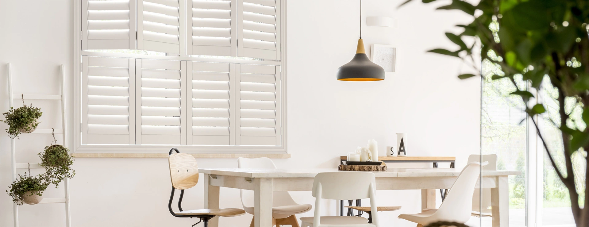 A bright white dining room featuring elegant white shutters on the windows